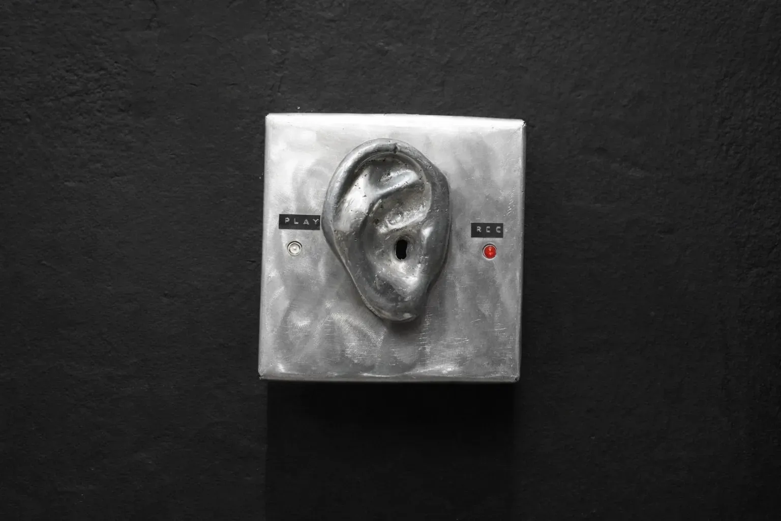 The ooho — metal ear device mounted on a wall, record and play buttons visible.